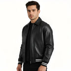 Man wearing a black leather jacket with white stripes on the sleeves against a white background