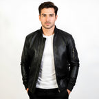 Man wearing a black leather jacket over a white shirt on a white background