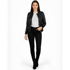 Woman wearing a black leather jacket, white shirt, and black pants on a white background