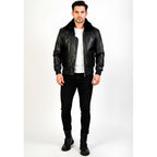 Man wearing a black leather jacket, white shirt, black pants, and black boots on a white background