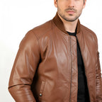 Brown leather jacket worn by a person on a white background