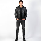 Man wearing a black leather jacket, black shirt, and black jeans on a white background
