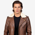 Man wearing a brown leather jacket with white fur collar on a plain background