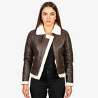 Woman wearing a brown leather jacket with white fur trim on a white background
