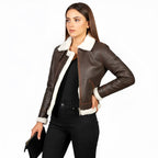 Woman wearing a brown leather jacket with white fur lining on a white background