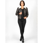 Woman wearing a black leather jacket with white fur lining on a white background