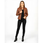 Woman wearing a brown leather jacket and black pants on a white background