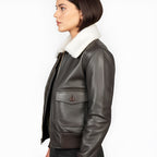 Brown leather jacket with white fur lining worn by a person on a white background