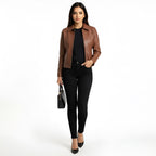 Woman wearing a brown leather jacket and black pants on a white background