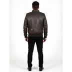 Man wearing a dark leather jacket and black pants on a white background