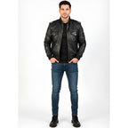 Man wearing a black leather jacket and blue jeans on a white background